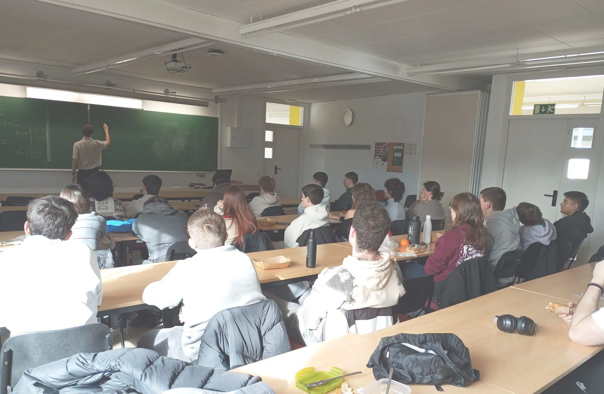 Un membre del Club fent una presentació a la pissarra davant d'una aula plena